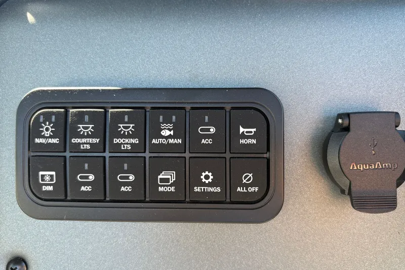Slide: The Image of Control panel of 2027 Sun Tracker Fishin' Barge 22 DLX with various switches and AquaAmp USB port. - 42