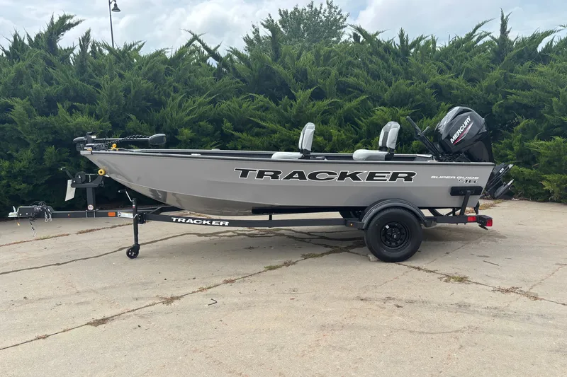 The Image of 2027 Tracker Super Guide V-16 T boat on trailer, parked outdoors. - 0