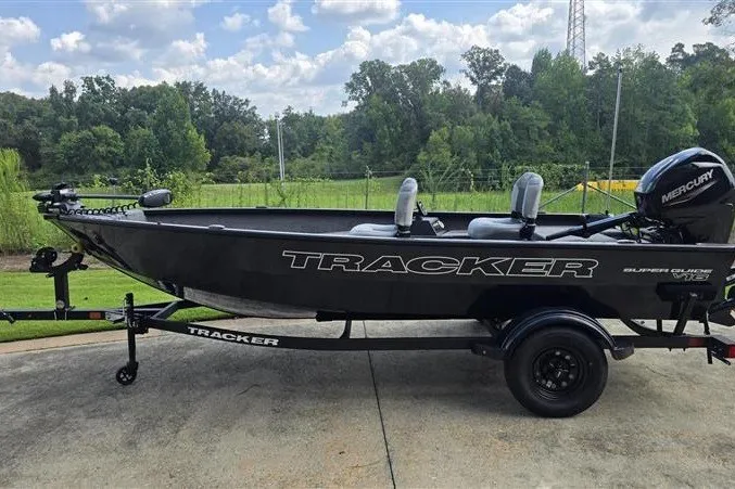 The Image of 2027 Tracker Super Guide V-16 T boat on trailer, parked outdoors. - 0