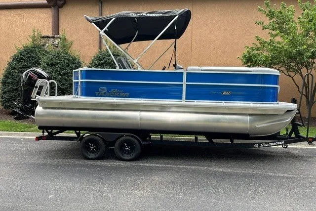 The Image of 2027 Sun Tracker Party Barge 20 DLX pontoon boat on trailer, parked outdoors. - 0