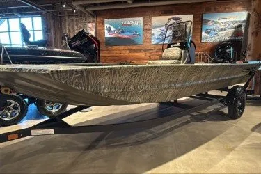 The Image of 2027 Tracker Grizzly 1860 CC boat displayed in a showroom with promotional posters. - 0