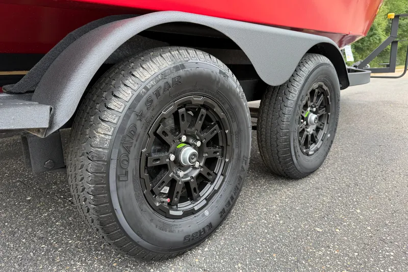 Slide: The Image of Trailer wheels of a 2027 Tracker Targa V-18 WT on asphalt. - 15
