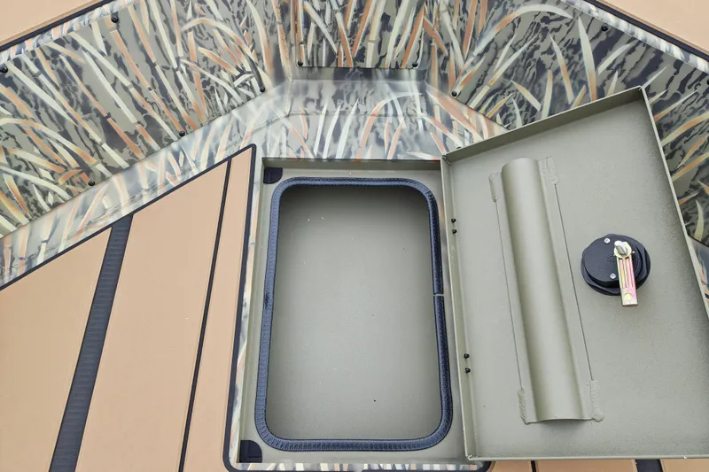 Slide: The Image of The image shows the interior of a Tracker Grizzly 1756 T Marsh boat with an open storage compartment. - 17