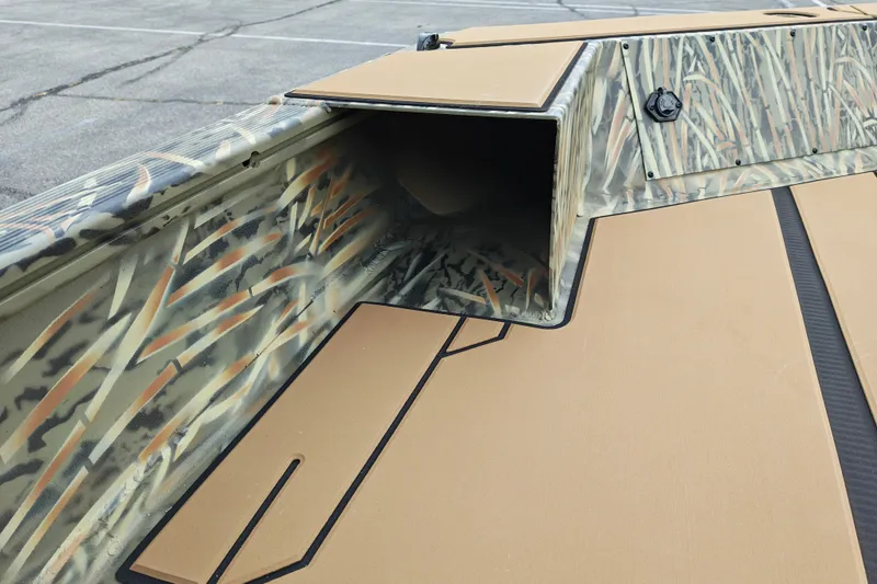 Slide: The Image of 2027 Tracker Grizzly 1756 T Marsh boat interior with camouflage design and storage compartment. - 18