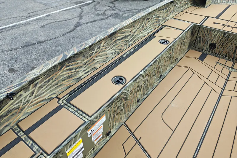 Slide: The Image of 2027 Tracker Grizzly 1756 T Marsh boat interior with camo design and storage compartments. - 19