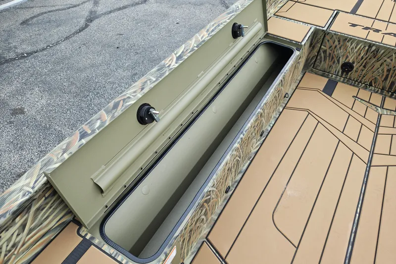 Slide: The Image of 2027 Tracker Grizzly 1756 T Marsh boat interior with storage compartment and camo design. - 20