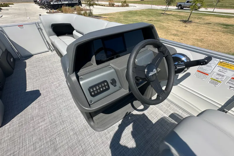 Slide: The Image of 2027 Sun Tracker Party Barge 20 DLX interior with steering wheel and seating. - 20