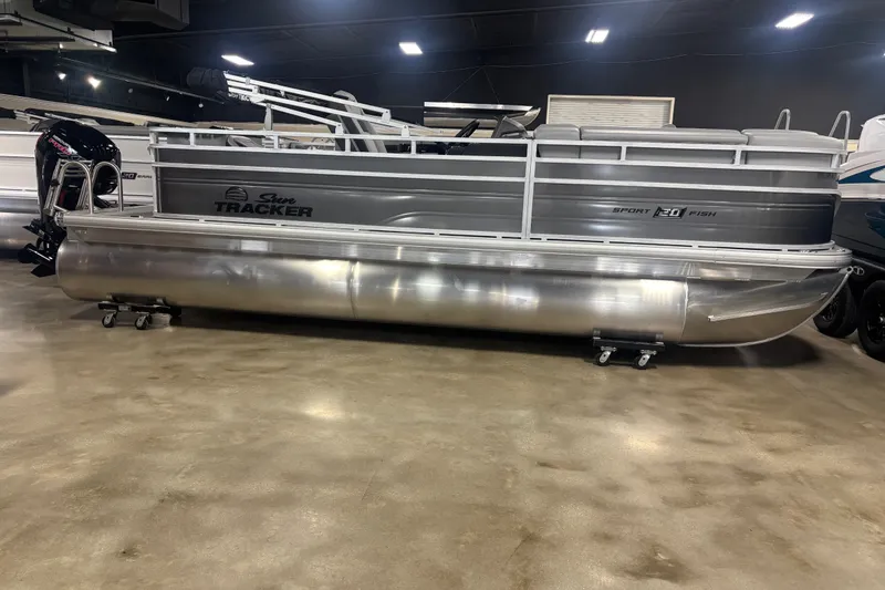 The Image of 2027 Sun Tracker SportFish 20 DLX pontoon boat displayed indoors on a showroom floor. - 1