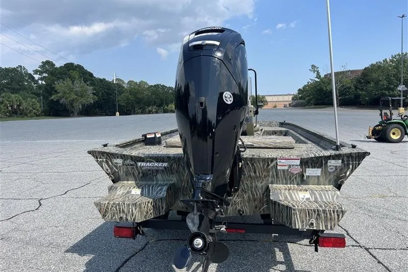 Slide: The Image of 2027 Tracker Grizzly 1860 CC boat with outboard motor in a parking lot. - 72