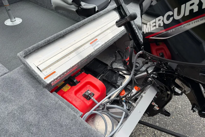 Slide: The Image of Tracker Super Guide V-16 T 2027 boat interior with Mercury engine and red fuel tank. - 15