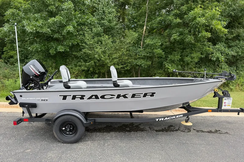 The Image of 2027 Tracker Super Guide V-16 T fishing boat on trailer, parked outdoors. - 0