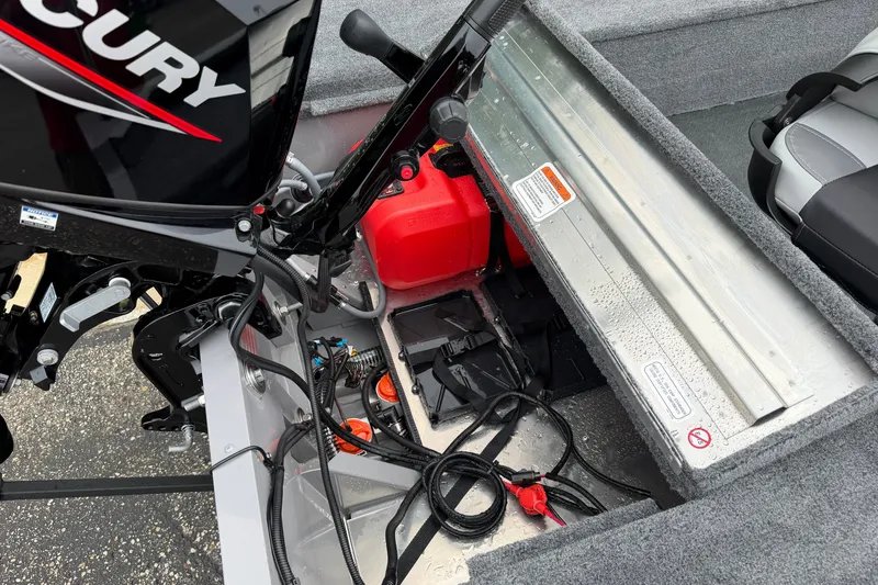 Slide: The Image of Tracker Super Guide V-16 T 2027 boat interior with Mercury engine and red fuel tank. - 16
