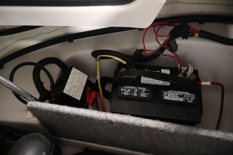 Slide: The Image of Battery compartment of a 2019 Scarab 165 G boat, showing wiring and connections. - 24