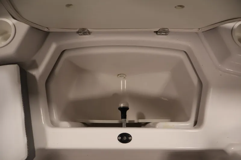 Slide: The Image of 2019 Scarab 165 G boat storage compartment with open lid, showcasing interior space. - 11