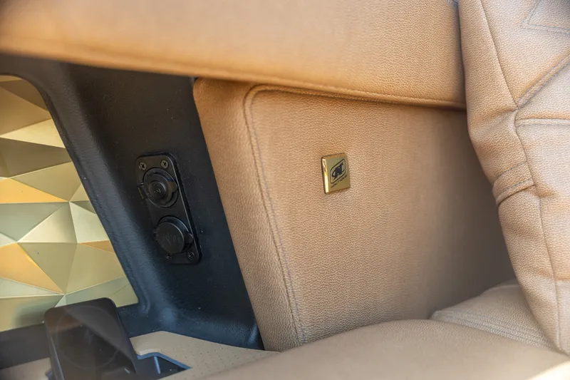 Slide: The Image of Interior detail of 2026 Nautique Super Air Nautique G25 Paragon with tan upholstery and power outlet. - 26