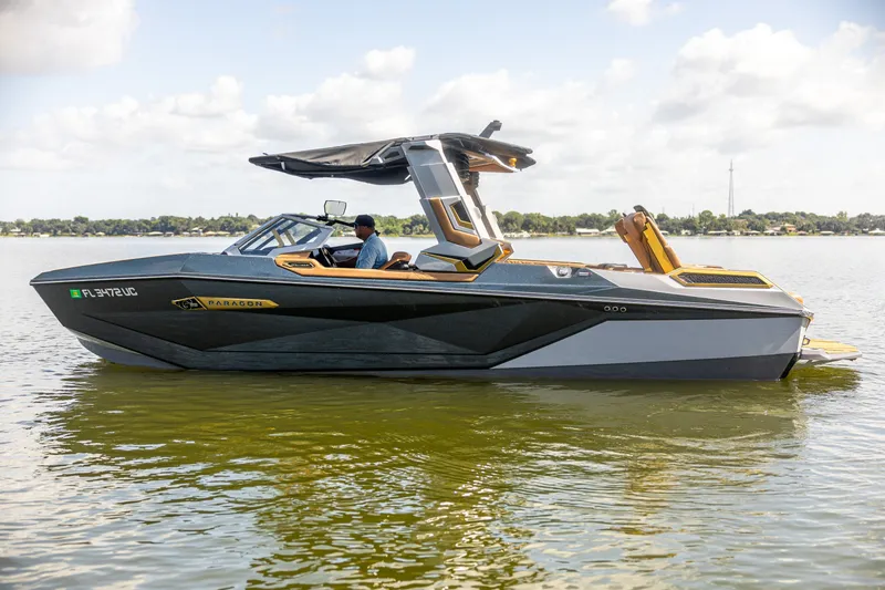 Slide: The Image of 2026 Nautique Super Air Nautique G25 Paragon boat on calm water, side view. - 12