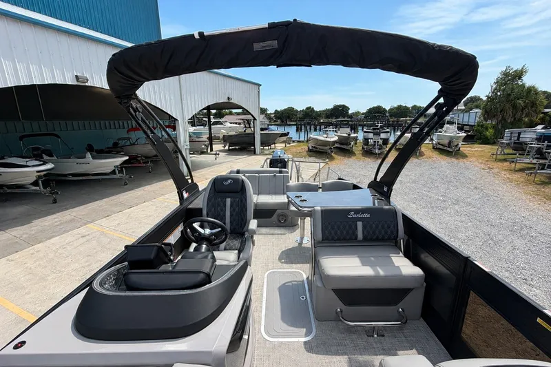 Slide: The Image of 2026 Barletta Lusso 25UE pontoon boat with sleek interior and modern design at a marina. - 18