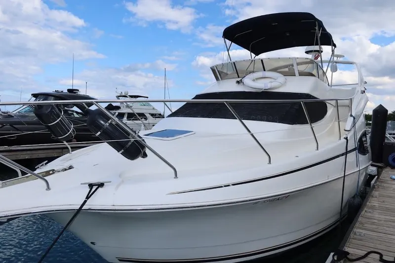 Slide: The Image of 2000 Silverton 330 Sport Bridge yacht docked at marina under blue sky. - 5