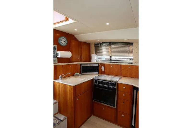 Slide: The Image of Interior of 2000 Silverton 330 Sport Bridge yacht kitchen with wood cabinetry and modern appliances. - 12