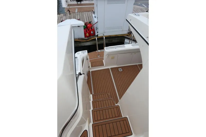Slide: The Image of 2000 Silverton 330 Sport Bridge boat deck with wood finish, docked at marina. - 23