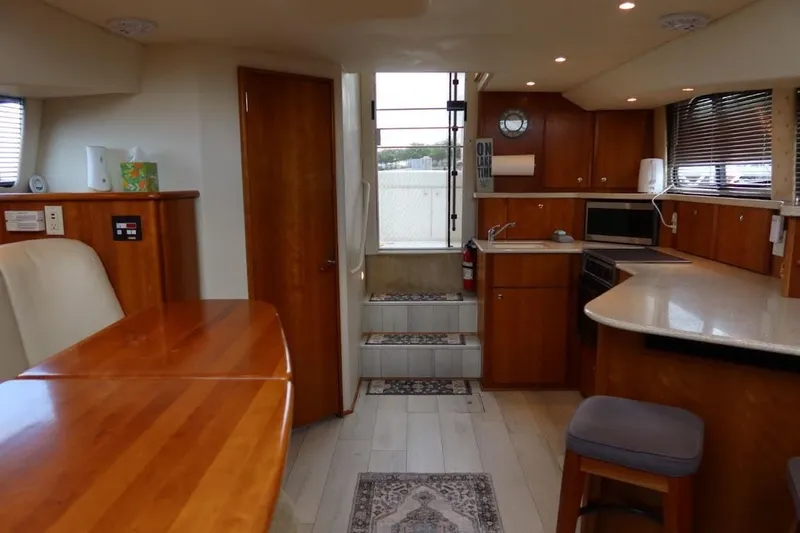 Slide: The Image of Interior of a 2000 Silverton 330 Sport Bridge yacht with wood finishes and modern amenities. - 11