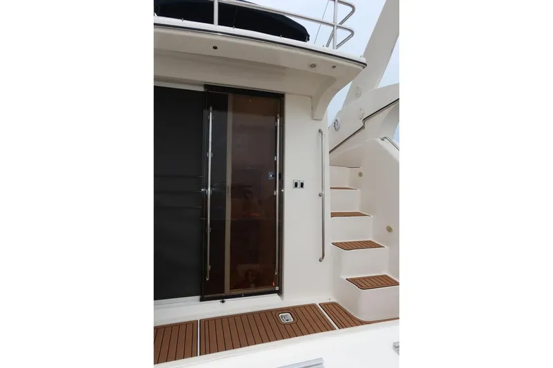 Slide: The Image of Staircase and door on 2000 Silverton 330 Sport Bridge yacht, featuring teak accents. - 14