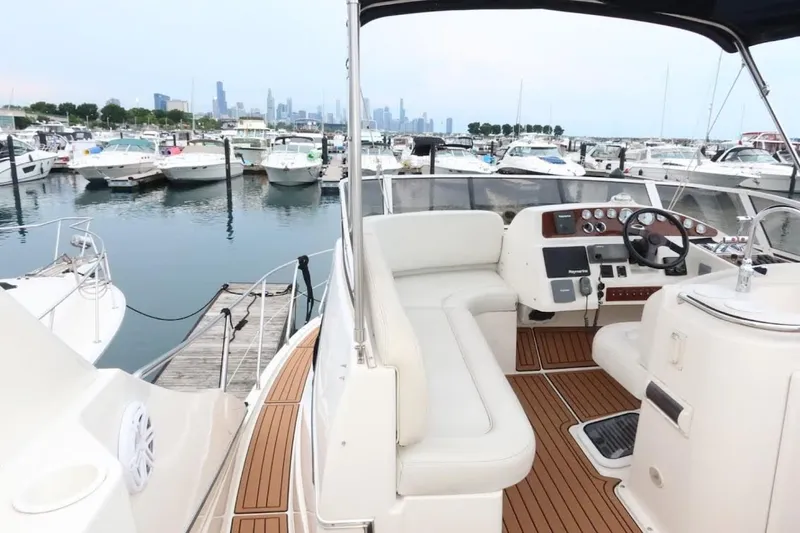 Slide: The Image of 2000 Silverton 330 Sport Bridge yacht docked in a marina with city skyline view. - 19
