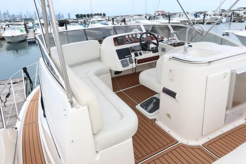 Slide: The Image of 2000 Silverton 330 Sport Bridge yacht interior with helm and seating area at marina. - 21