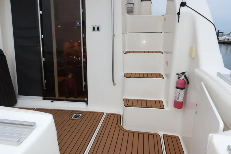 Slide: The Image of Staircase and deck of 2000 Silverton 330 Sport Bridge with fire extinguisher. - 24