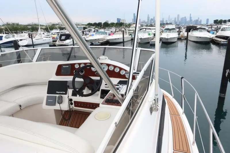 Slide: The Image of 2000 Silverton 330 Sport Bridge yacht helm with marina view. - 16