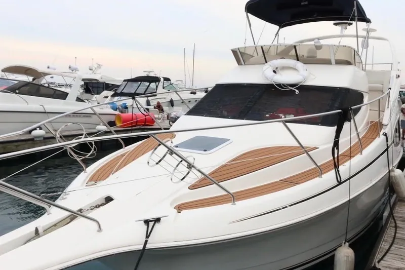 Slide: The Image of 2000 Silverton 330 Sport Bridge yacht docked at marina, featuring sleek design and spacious deck. - 6