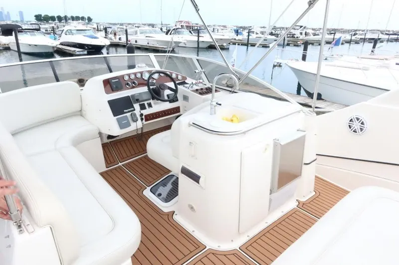 Slide: The Image of 2000 Silverton 330 Sport Bridge yacht interior with helm, seating, and marina view. - 15