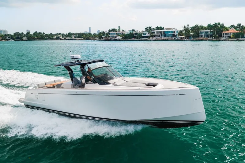 Slide: The Image of 2021 Pardo Yachts P38 cruising on turquoise water near luxury waterfront homes. - 18