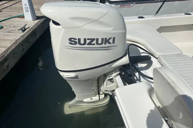 Slide: The Image of Suzuki outboard motor on a 2021 Savannah SS21 boat docked at a marina. - 20