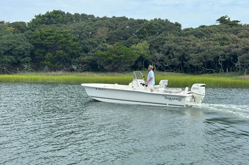 The Image of Man piloting 2021 Savannah SS21 boat on calm water near lush greenery. - 0