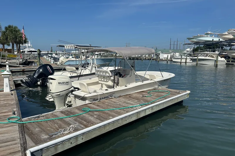 Slide: The Image of Boat docked at marina, Savannah SS21 model, 2021, with Suzuki outboard motor. - 26