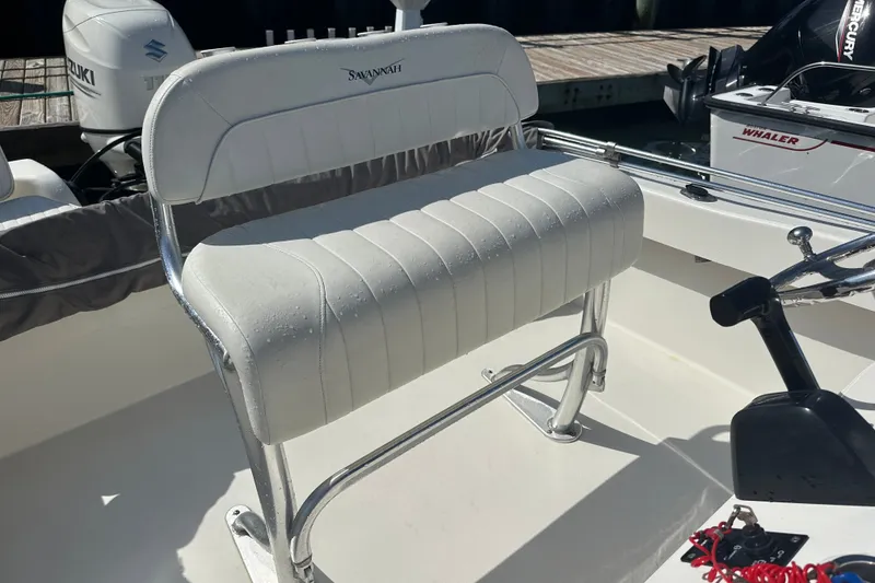 Slide: The Image of White Savannah SS21 boat seat with chrome frame, 2021 model, in a sunny marina setting. - 14