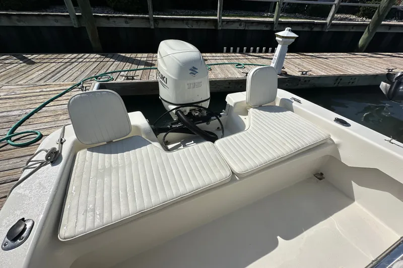Slide: The Image of 2021 Savannah SS21 boat with Suzuki outboard motor, docked on wooden pier. - 19