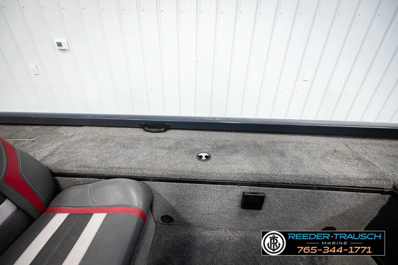 Slide: The Image of 2021 Ranger RT188C boat interior with gray and red seating, carpeted deck, and storage compartment. - 25