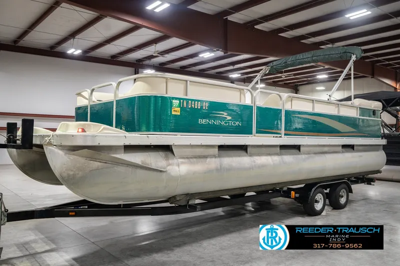 Slide: The Image of 2000 Bennington 227L pontoon boat on trailer in indoor storage facility. - 1