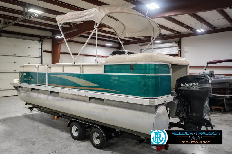 Slide: The Image of 2000 Bennington 227L pontoon boat with Johnson outboard motor in a garage setting. - 10