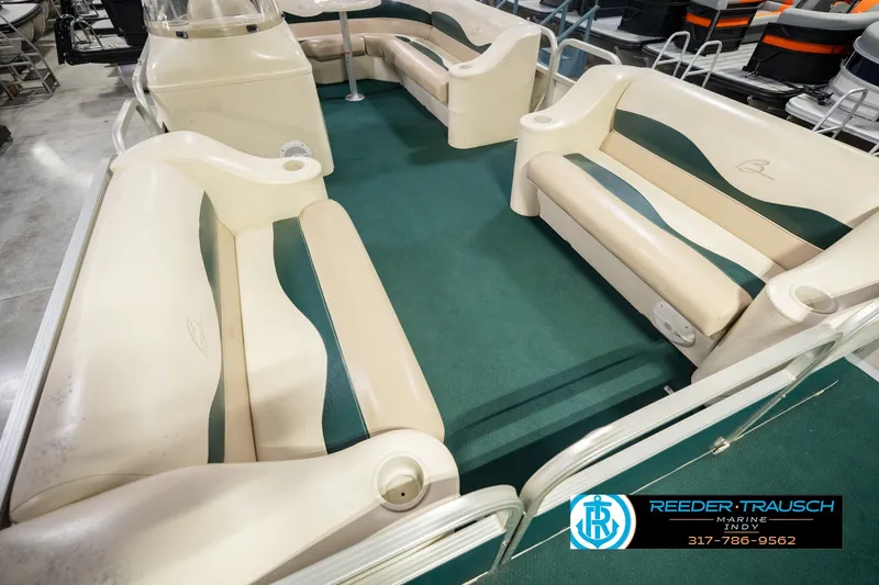 Slide: The Image of Interior of a 2000 Bennington 227L pontoon boat with green carpet and beige seating. - 14