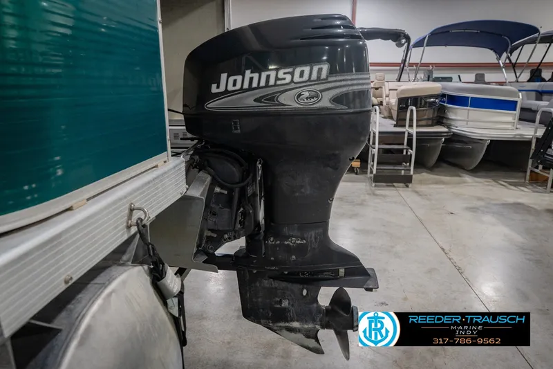 Slide: The Image of Bennington 227L 2000 with Johnson outboard motor in a showroom setting. - 48