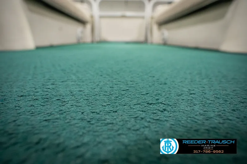 Slide: The Image of Green carpeted floor of a 2000 Bennington 227L boat interior. - 47