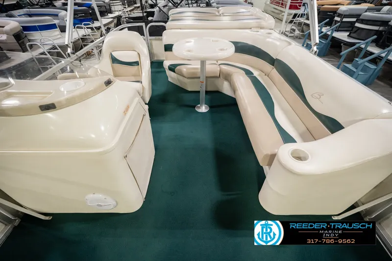 Slide: The Image of Interior of a 2000 Bennington 227L boat with green carpet and beige seating. - 20