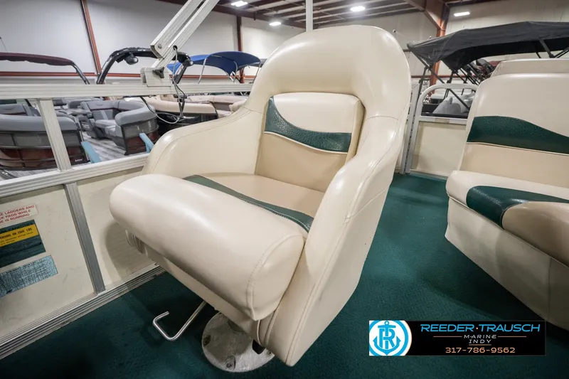 Slide: The Image of Bennington 227L 2000 boat seat in showroom, featuring beige and green upholstery. - 41