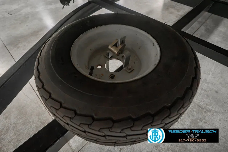 Slide: The Image of Spare tire on a Bennington 227L trailer, 2000 model, displayed in a showroom. - 54
