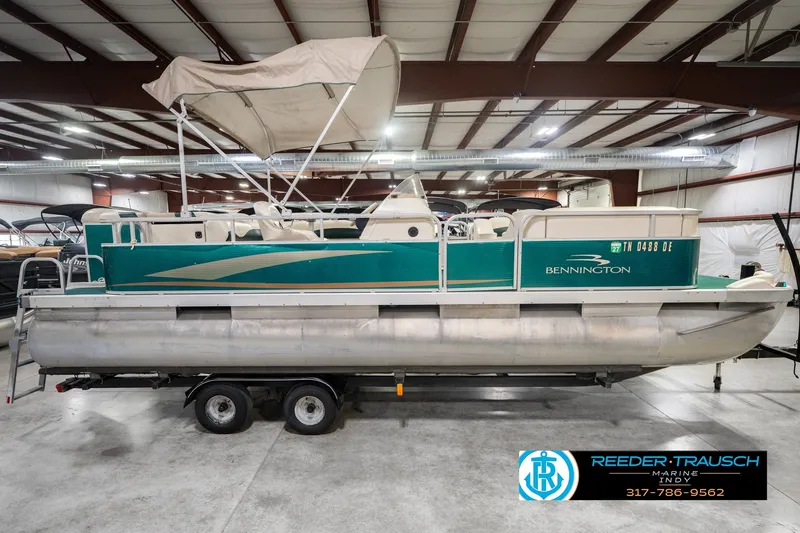 Slide: The Image of 2000 Bennington 227L pontoon boat with canopy in indoor storage facility. - 6