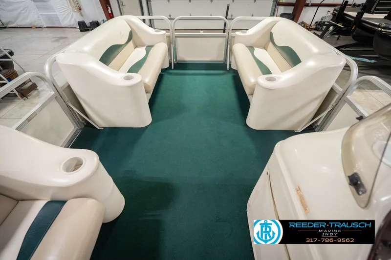 Slide: The Image of Interior of a 2000 Bennington 227L pontoon boat with green carpet and white seating. - 24