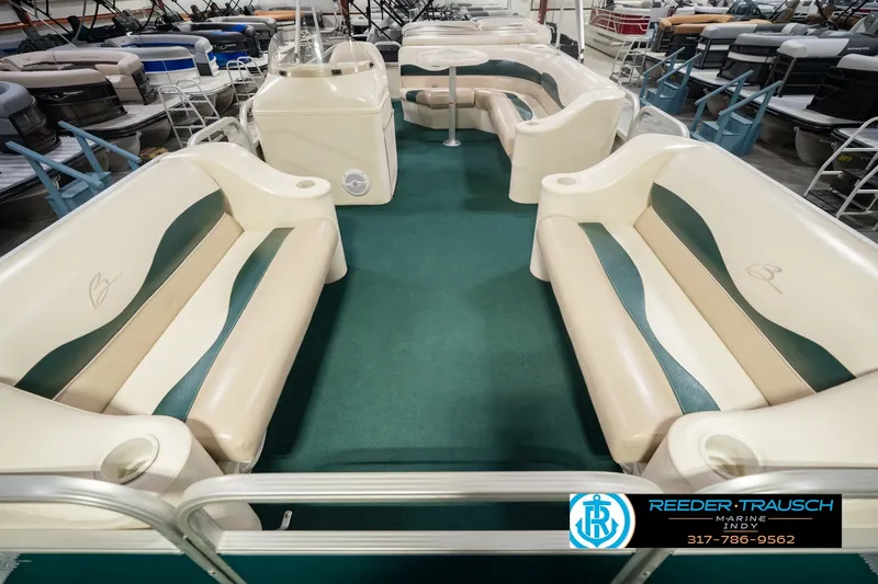 Slide: The Image of Interior of a 2000 Bennington 227L pontoon boat with green carpet and beige seating. - 18